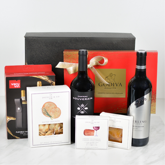 Black gift box with two bottles of wine, box of water crackers, cabernet cheese spread, box of dried pears, box of Godiva chocolates, and Vacu Vin wine cooler sleeve