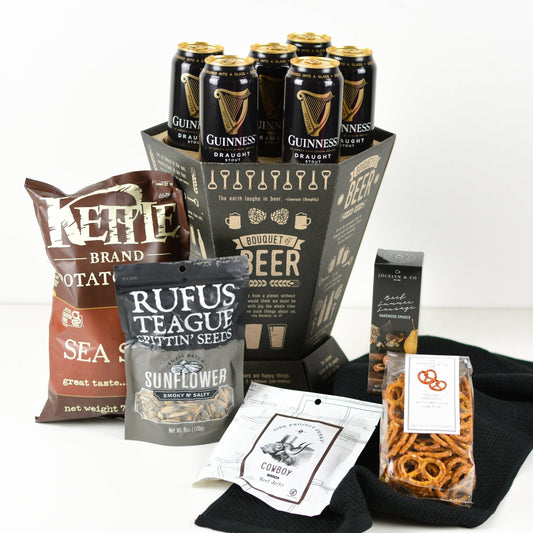 Bouquet of Beer container, six cans, of Guinness stout, Kettle sea salt chips, smoky and salty sunflower seeds, one package of beef jerky, pretzels, beef summer sausage and a black kitchen towel