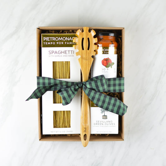 Kraft color pinstripe box with box of spaghetti, jar of pasta sauce, box of green olives, a wood pasta spoon tied with a green and black ribbon